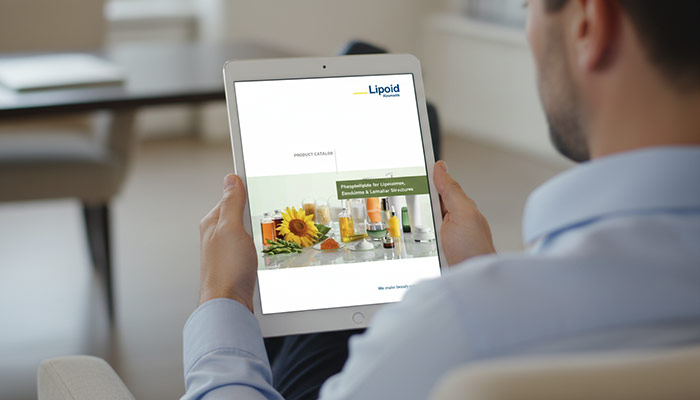 Homem segurando tablet com a capa do catálogo de fosfolipídios da Lipoid Kosmetik.